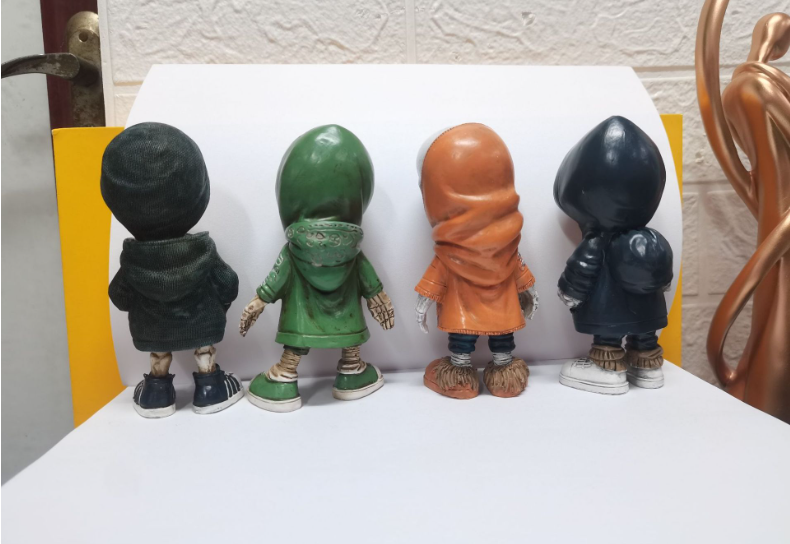 Four skeleton figurines in hoodies, back view