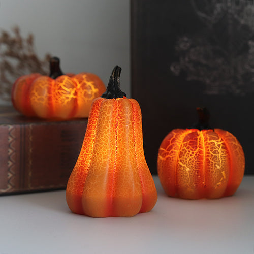 LED pumpkin lanterns lit up on a shelf