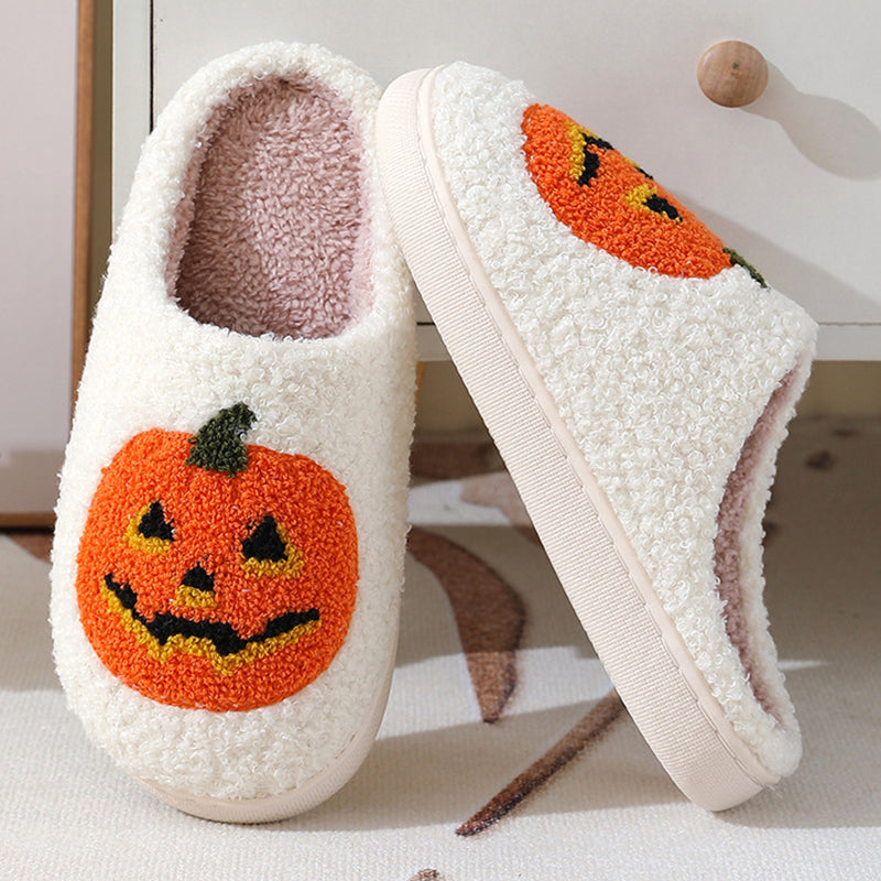 White jack-o'-lantern slippers on a Halloween table
