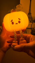 Glowing pumpkin night light held in a hand